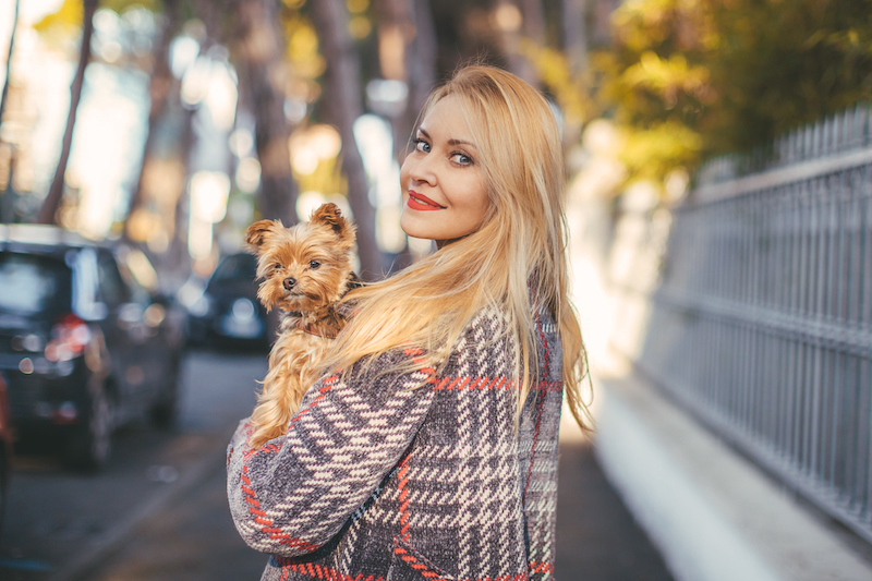 blond woman with a little dog in her arms