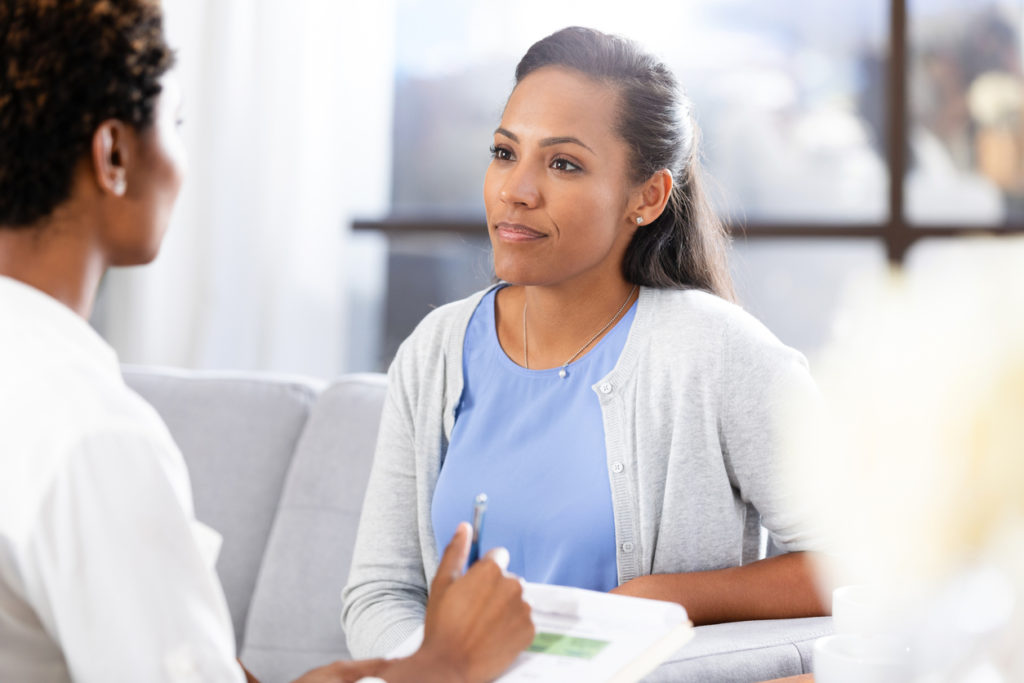 Mid adult woman talking to doctor