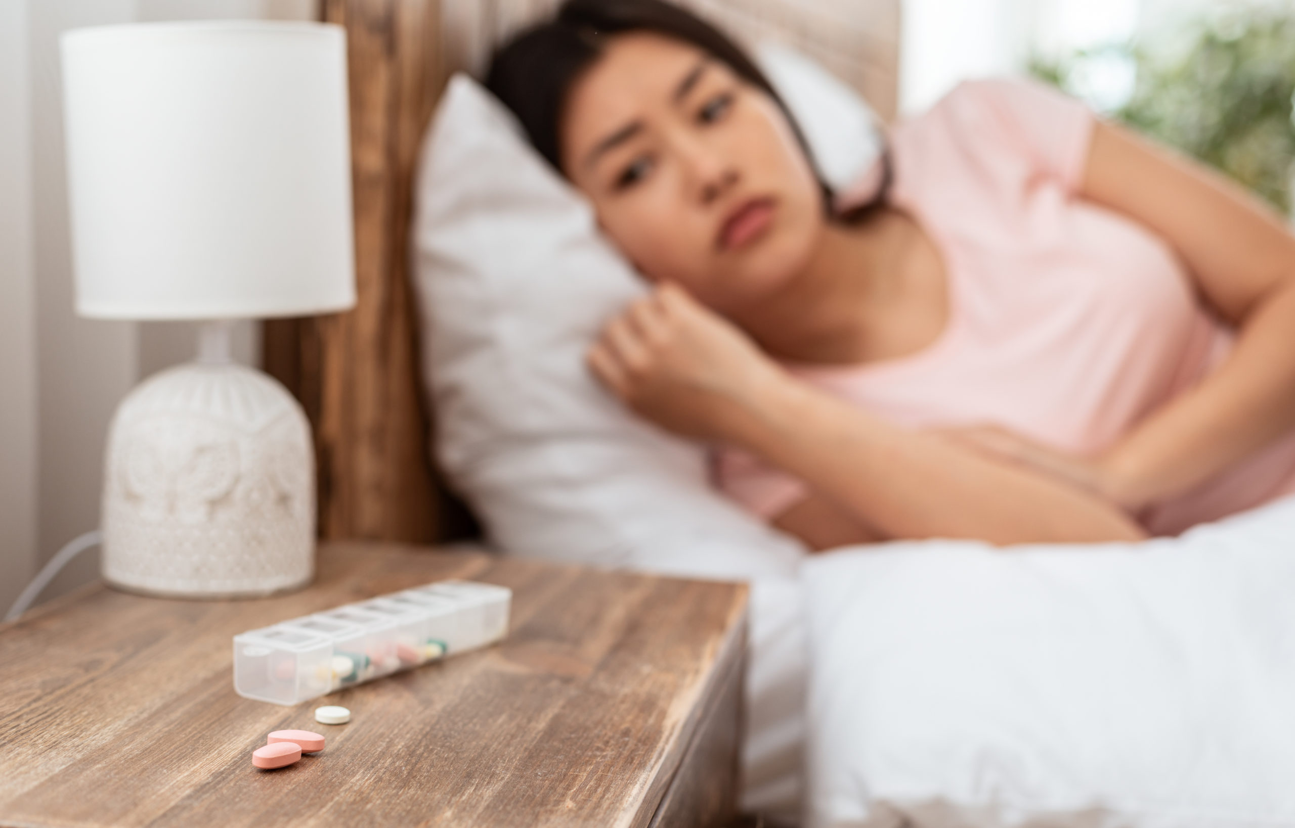 Women Restless with sleeping pills on bedside table