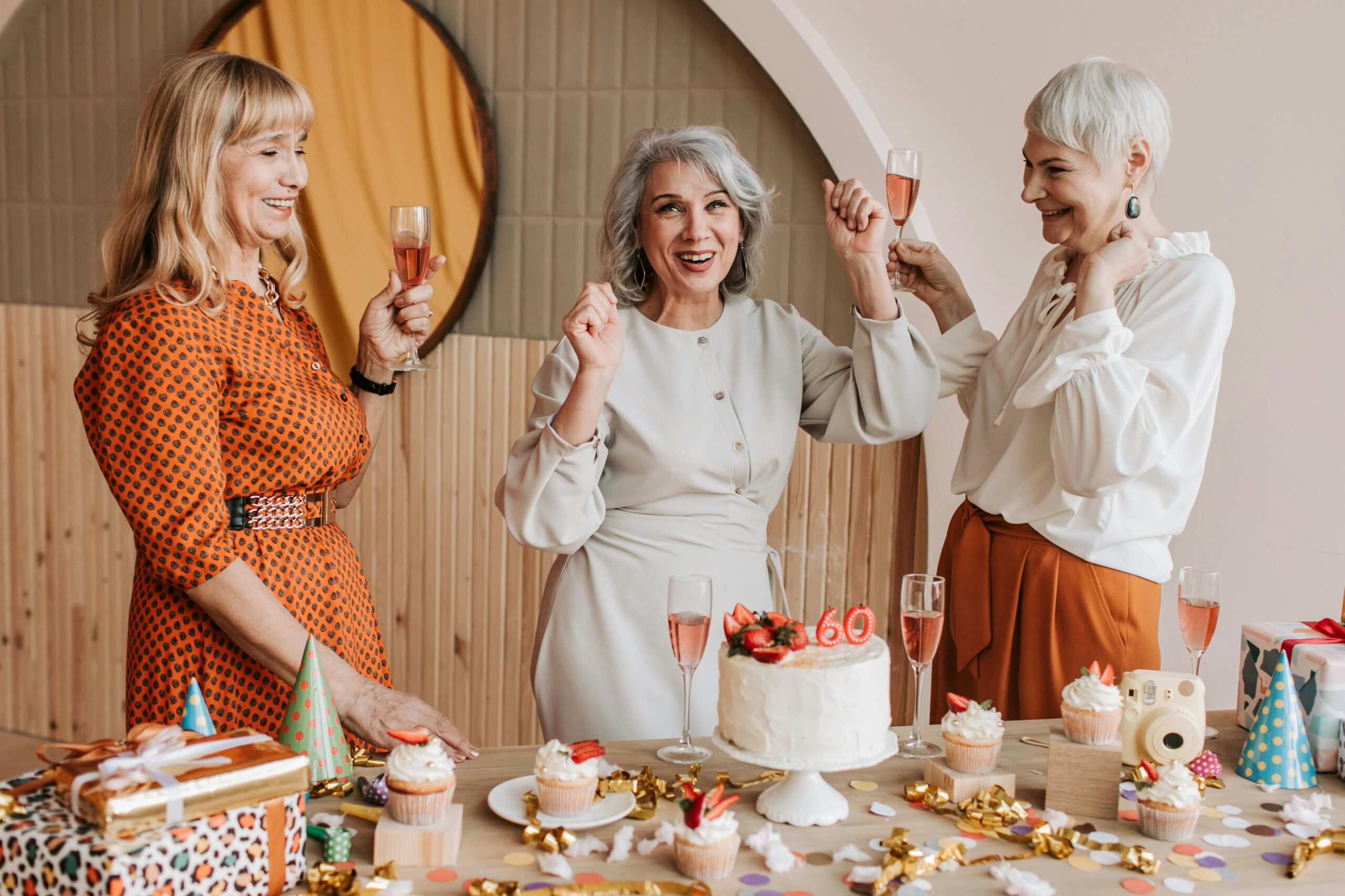 three middle aged women looking happy having drinks