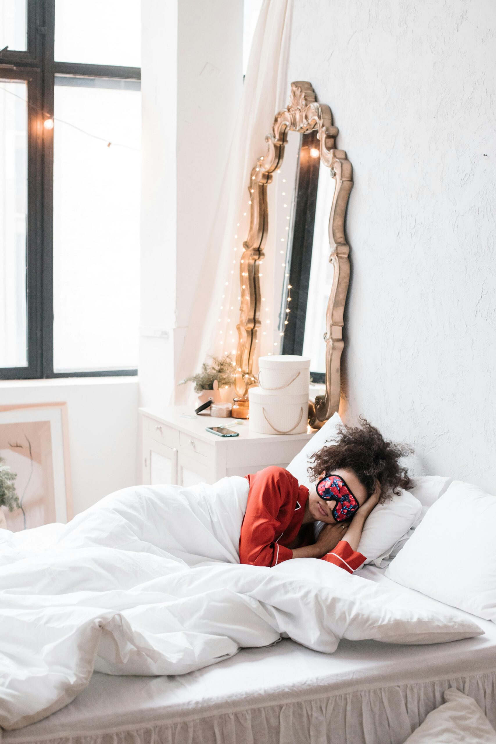 Peaceful scene of a woman resting in a stylish bedroom with vintage decor and natural lighting.