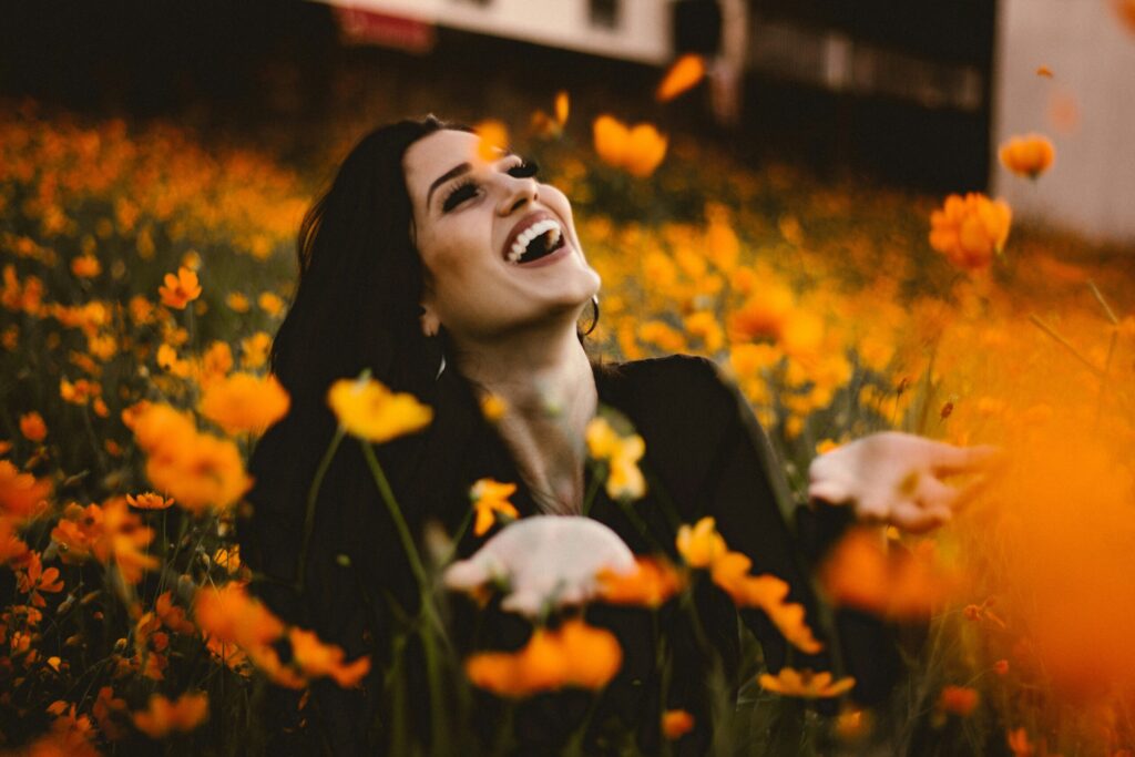 woman sitting in sunflower field smiling