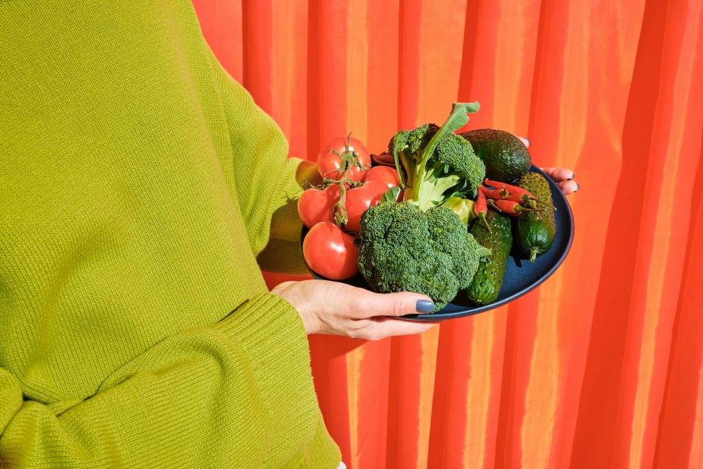 woman holding a plate of vegetables
