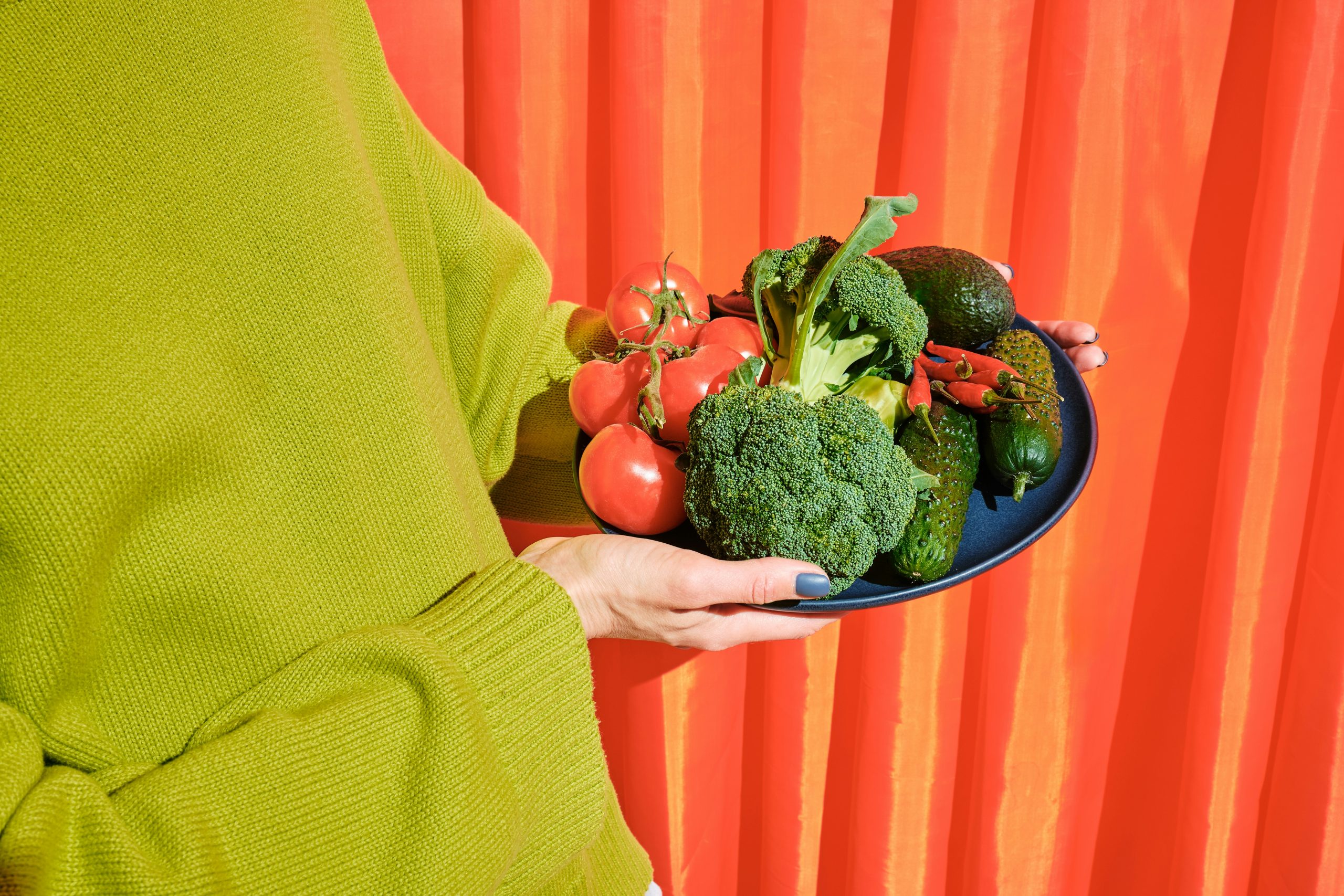 woman holding a plate of vegetables
